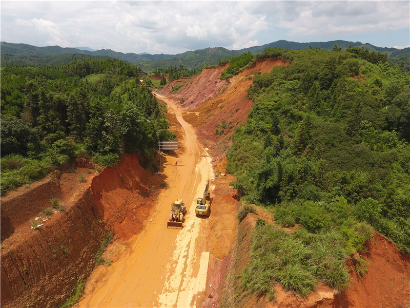7月13日，工程機械在廣西三江侗族自治縣古宜鎮搶修塌方中斷的道路。