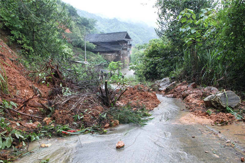在湖南省邵陽市綏寧縣長鋪子苗族侗族鄉芷坪村，被大雨沖下的山石和泥土阻塞道路（6月26日攝）。
