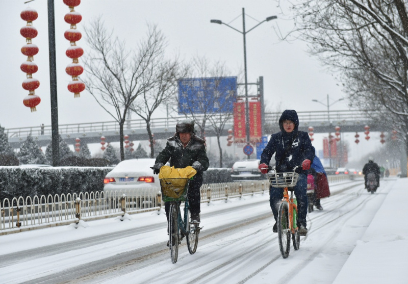 2月21日，在太原市濱河東路，兩位市民冒雪騎行。