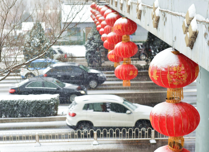 2月21日，大雪飄落在太原市濱河東路路邊的燈籠上。