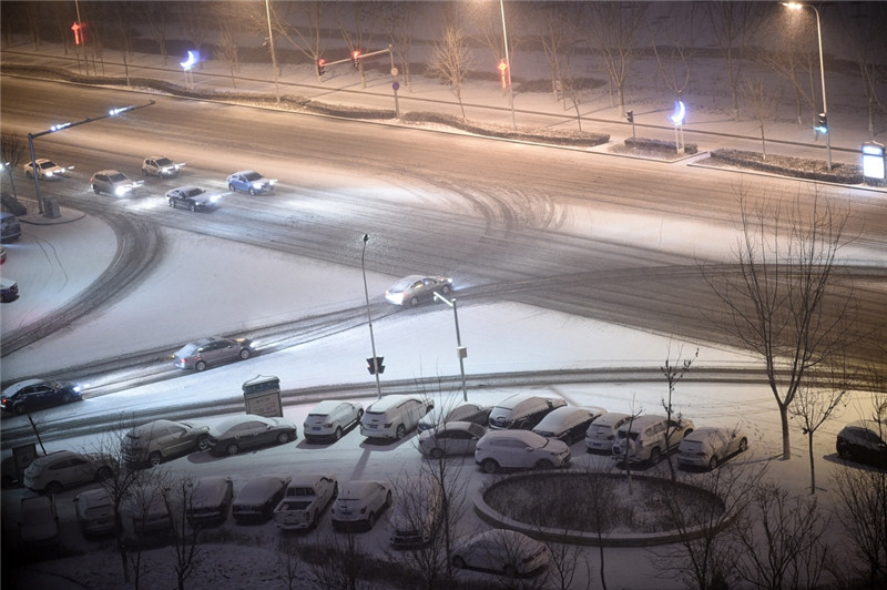 2月20日，在銀川市街頭，車輛在雪中行進。