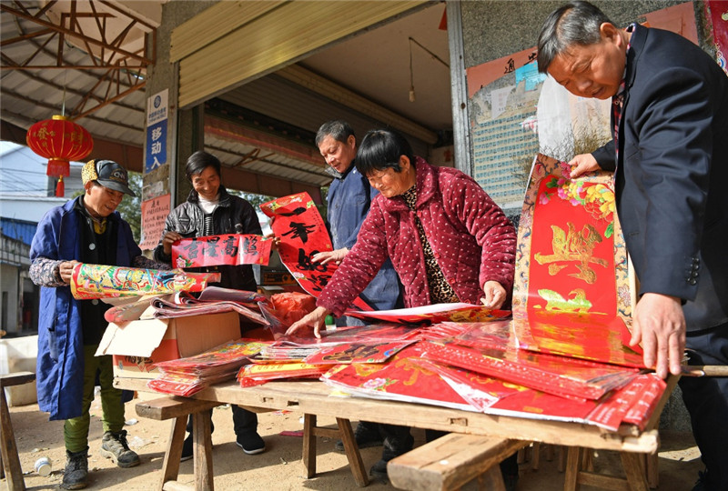 江西鄱陽縣古縣渡鎮張家坽村村民在集市上選購春聯（1月24日攝）。