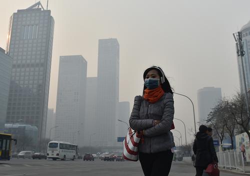 11月28日，一名戴口罩的行人在霧霾下的北京街頭行走。當日，北京出現重污染天氣。