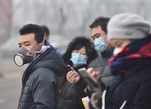 12月8日，戴著口罩的市民在通州區一處公交車站候車