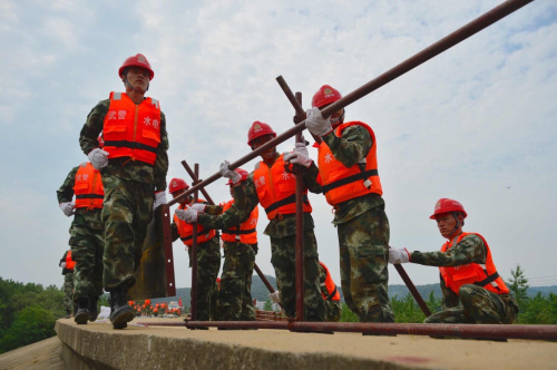 5月18日，武警水電部隊戰士使用新發明的鋼模子堤防堵模擬的漫溢險情。當日，江西省“抗洪搶險2016”軍地聯合防汛演習在九江市長江大堤益公堤展開。這也是2006年來江西省規模最大的防汛演習。此次演習分別進行了舟艇演練、管涌崩岸險情處置、滿溢決口險情處置等多個項目，并使用無人機、鋼模子堤、充氣式圍井等多種新型裝備。新華社記者 周密 攝