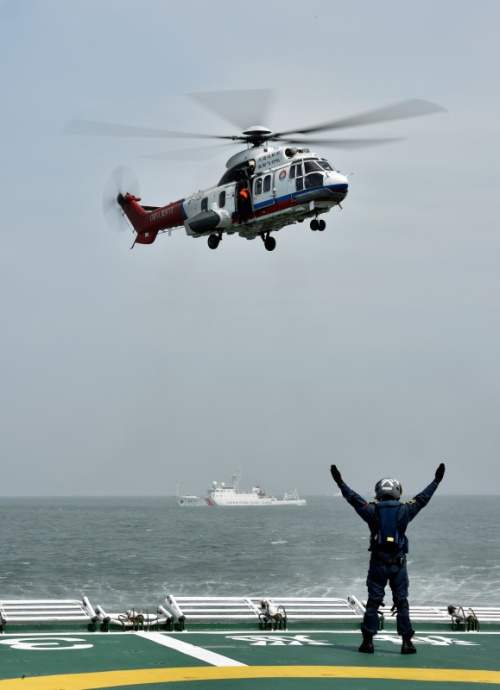 5月19日，交通運輸部南海救助飛行隊的直升機和救助人員在演習現場海域救助落水人員。新華社記者 劉大偉 攝