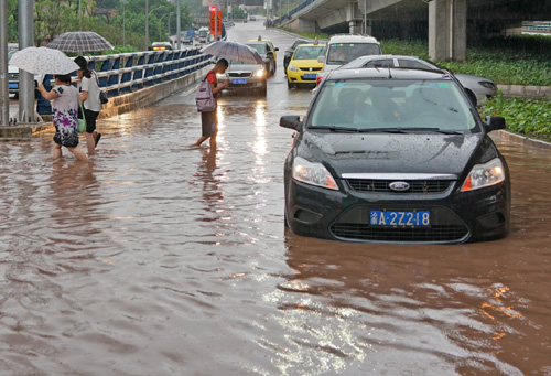 6月24日，重慶市江北區石馬河轉盤處積水嚴重，車輛涉水行駛。