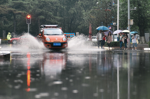 6月30日，汽車經過長春市一處積水路段。新華社記者許暢攝