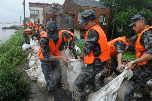 7月3日，陸軍東部戰區第十二集團軍臨汾旅戰士在宣城市宣州區沈村鎮勝利圩加固堤防。新華社記者 孟鼎博 攝