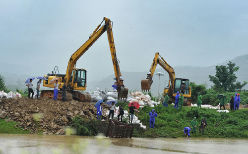 7月5日，在岳陽市云溪區，工作人員在一處堤壩隱患處加緊搶修。連日來，湖南省遭遇嚴重暴雨洪澇災害，當地干部群眾齊心協力搶險救災。記者4日從湖南省防汛抗旱指揮部了解到，據初步統計，本輪強降雨共造成湖南省長沙、常德、岳陽等9市州36個縣市區317個鄉鎮52.23萬人受災，緊急轉移4.09萬人，倒塌房屋600間。湖南省防指決定自4日12時起將防汛應急響應提升至二級，益陽、岳陽、常德三市為當前防汛抗災工作重點區域，要求各級各部門按照應急響應要求，切實做好防汛抗洪各項工作。