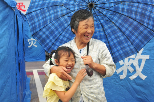 7月6日，9歲的鄭君如（左）與奶奶在舒城縣桃溪中學安置點的帳蓬前。新華社發（陳力 攝）