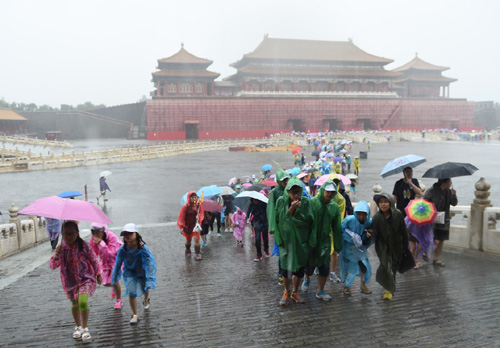 7月20日，游客冒雨在北京故宮游覽。北京市氣象臺7月20日8時40分更新發布暴雨黃色預警，預計20日本市大部分地區仍有暴雨、局地大暴雨。
