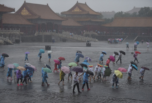 7月20日，游客冒雨在北京故宮游覽。