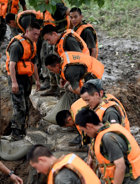 7月21日，在河南省安陽市安陽河崇義段堤壩決口處，解放軍官兵用沙袋封堵決口。7月20日下午，河南省安陽市安陽河崇義段堤壩出現決口險情，400多名解放軍官兵趕到現場后，連續奮戰，堅守在封堵決口第一線。新華社記者 李安 攝