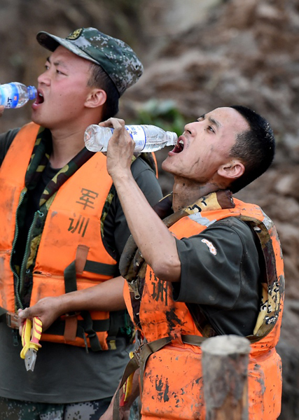 7月21日，在河南省安陽市安陽河崇義段堤壩決口處，解放軍戰士在搶險間歇喝水。新華社記者 李安 攝