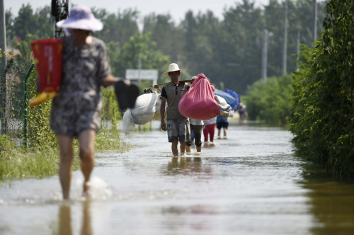 7月28日，一些當地村民返回家中搶運出了一些所需物資。新華社記者 陳曄華 攝