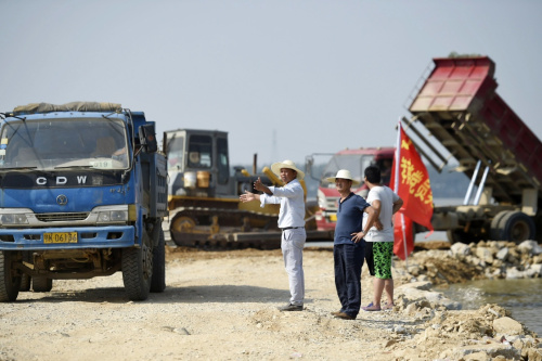 7月28日，施工人員在指揮施工車輛對潰口進行封堵。新華社記者 陳曄華 攝