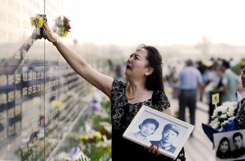 7月28日，一名女士在唐山大地震罹難者紀念墻悼念遇難者。新華社記者 吳曉凌 攝