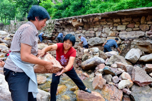 8月6日，河北省沙河市柴關鄉陰河溝村村民在壘筑被洪水沖毀的道路。新華社記者 牟宇 攝