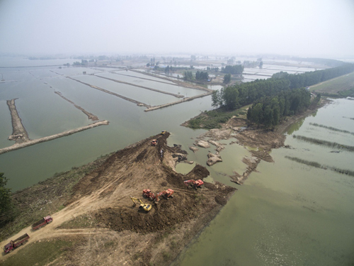 8月17日，工作人員在對漢北河胡市段河堤潰口處進行封固。 今年汛期以來，湖北多地受嚴重洪澇災害影響，損失巨大。各受災地區的災后重建工作也在洪水消退后陸續開展。湖北天門、京山等受災最嚴重的地區，部分受災農田已完成復播，水毀道路正在修復，潰口的河堤正在加緊封固，災后重建工作有序進行。
