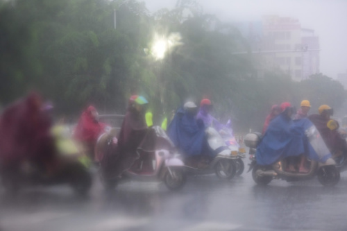 10月13日，海南瓊海市民在雨中出行。