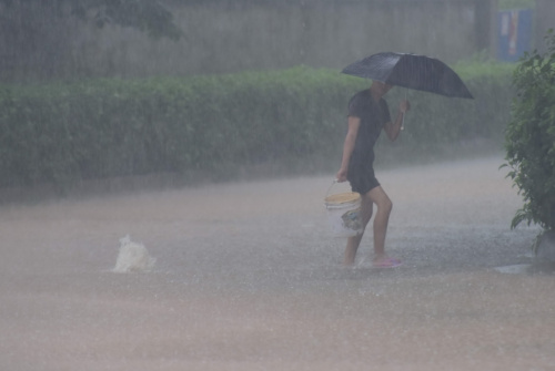 10月13日，海南瓊海市民在雨中出行。