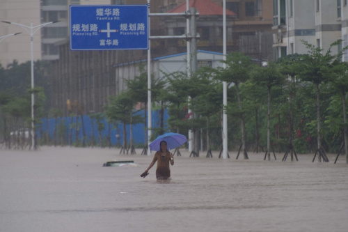 10月13日，海南瓊海市民在雨中出行。