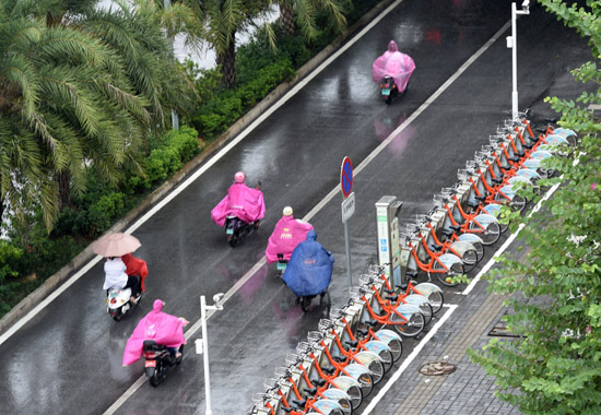 10月18日，市民在南寧市濱湖路冒著風雨出行。當日，受臺風“莎莉嘉”影響，廣西南寧、崇左、欽州、防城港、玉林、貴港等地發布臺風預警信號。