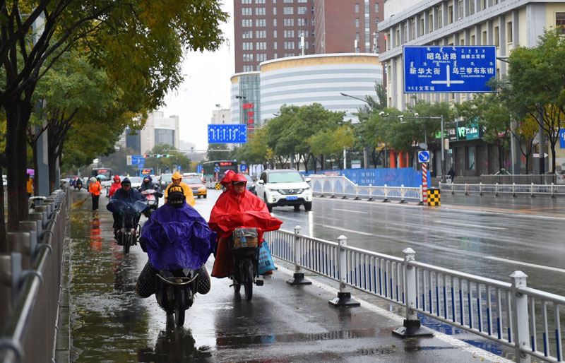   10月27日，在呼和浩特街頭，出行者在雨中駕車行駛。