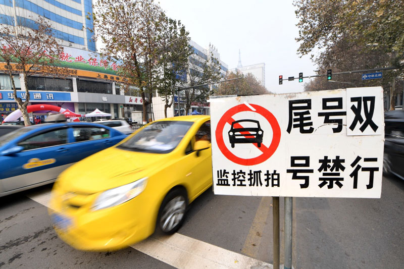 12月3日，車輛從河北省邢臺市守敬北路上的限號提示牌旁經過。