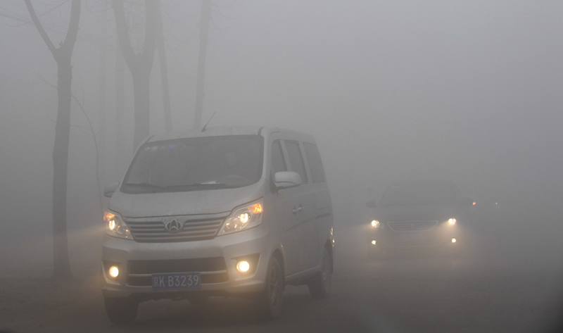 12月22日，車輛在霧霾籠罩下的河北省大城縣的一條公路上緩慢行駛。當日，河北南部局部地區出現重度霧霾天氣給當地交通和人們出行帶來了不便。