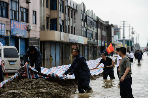 7月5日，在江蘇241省道常州市金壇區指前鎮段，搶險人員在緊張筑壩，保路疏水。新華社記者 季春鵬 攝