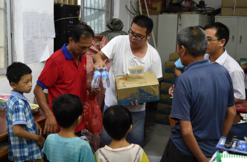 8月2日，在廣西蒼梧縣沙頭鎮參田村小學，當地村民領取物資準備在這里臨時安置。當日，臺風“妮妲”中心在廣東登陸后從蒼梧縣進入廣西境內。根據梧州氣象臺預報，“妮妲”過境時中心附近最大風力8級，并帶來大量雨水，臺風、強降雨區與蒼梧縣地震震區重疊。當地有關部門將因災受損房屋里的群眾撤離到安全地帶避險。目前，當地政府正加強對危險區域、災害隱患點的巡查和應急處置，嚴防余震和臺風帶來的次生災害。新華社記者 陸波岸 攝